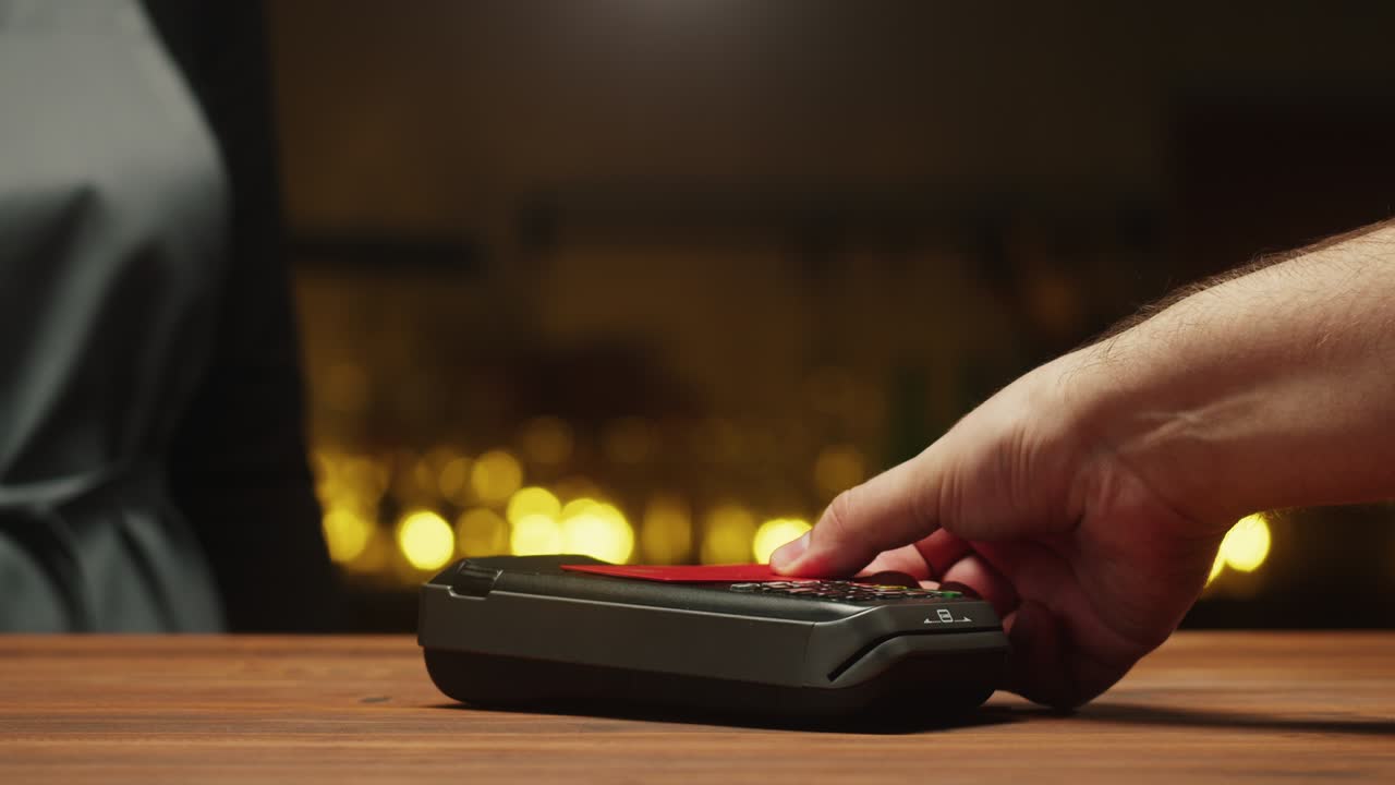 Paying with credit card close-up. Cashless shopping in restaurant or cafe. Touch-free and contactless payment concept. NFC technology and bank terminal.