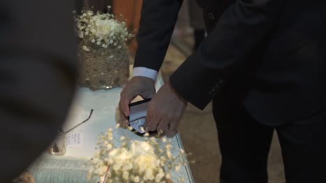 man taking out engagement ring from a box during wedding event with camera flash