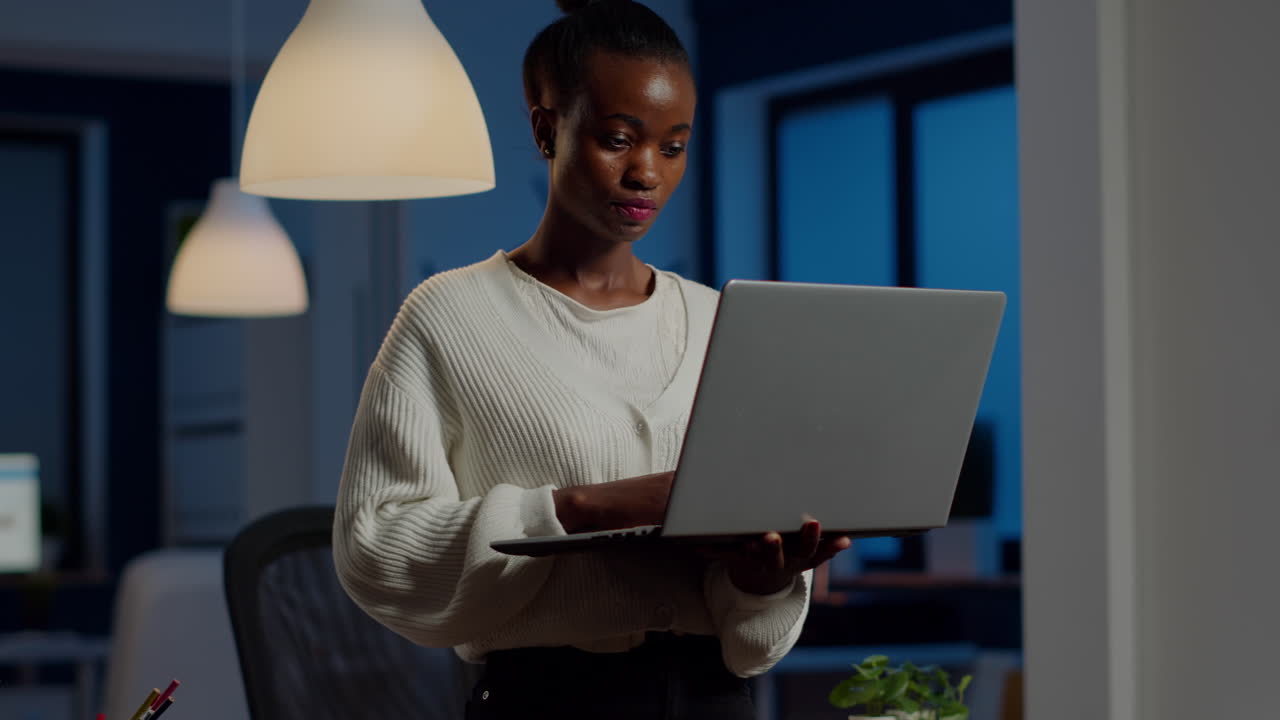 Black business woman looking at camera smiling holding laptop