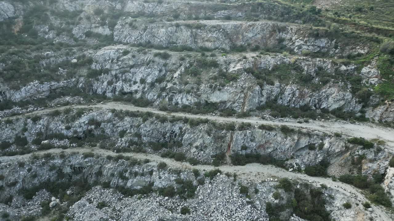 Dense fog enveloping abandoned quarry near sant fost de campsentelles, revealing terraced geological landscape with industrial remnants in barcelona's mediterranean environment