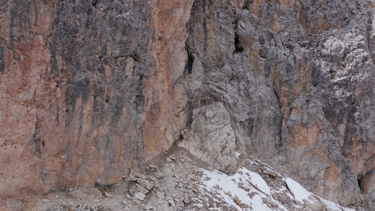 alpinista ascendiendo vía ferrata oskar schuster, montaña rocosa, montaña sassolungo dolomitas, italia