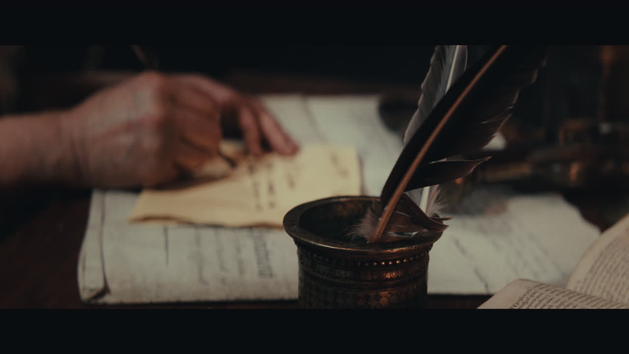 An old captain sits writes a letter inside the sailing ship cabin