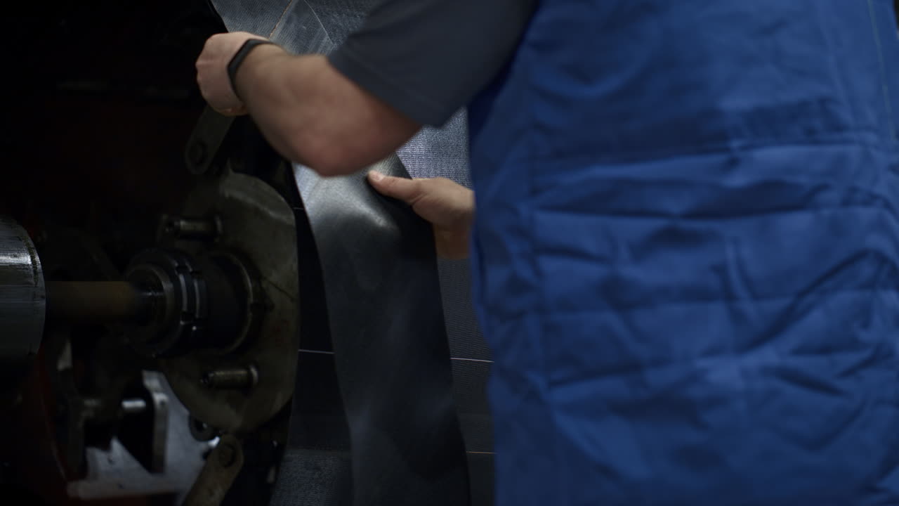 el proceso de producción de neumáticos de las manos de los trabajadores que operan en una instalación de fábrica moderna