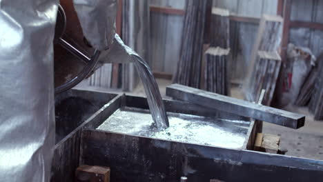 still shot with a slight pan down of liquid metal pouring in the foundry