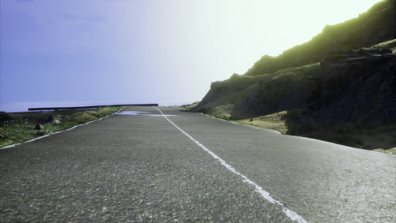 Sunny road winding through mountainous landscape during midday conditions