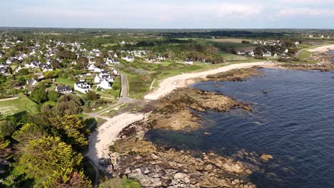 Coastal-village-with-rocky-shoreline-and-sandy-beaches-captured-in-an-aerial-view