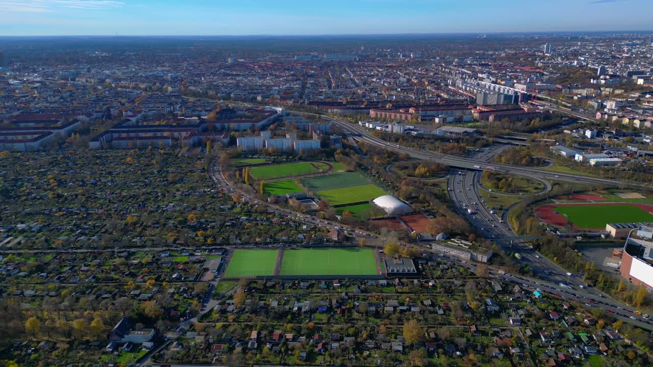 Berlin urban landscape featuring football pitches, a freeway, and residential areas from above. speed ramp hyper motion time lapse Gorgeous aerial view flight wide orbit overview drone