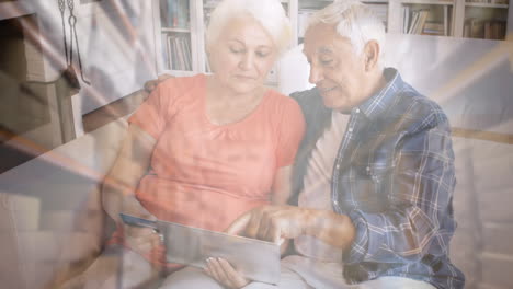 pareja de ancianos caucásicos en distanciamiento social comprando en línea en casa