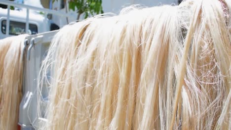 a pile of abaca fiber material is drying on top of a truck on a sunny day