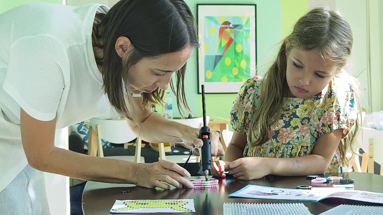 madre e hija haciendo artesanía juntos