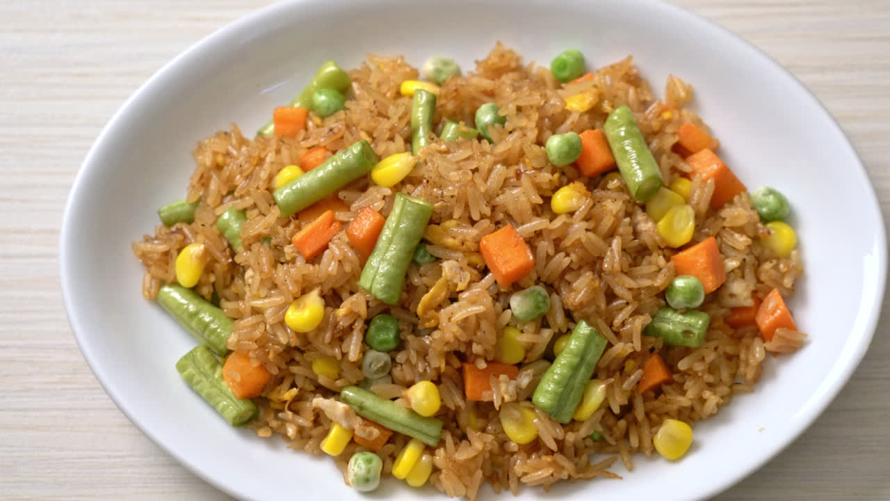 arroz frito con guisantes, zanahoria y maíz - estilo de comida vegetariana y saludable