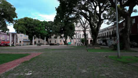 historic public square with cobblestone pavement and old trees