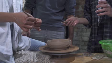 group of young adults learning pottery