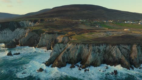 waves splashing against the beautiful white cliffs of ashleam in ireland during sunset