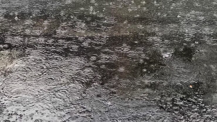 Close-Up of Rainfall Creating Mesmerizing Ripples and Patterns on the Road