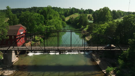 Historic-steel-truss-bridge-over-mirror-like-creek,-War-Eagle-Mill,-Arkansas