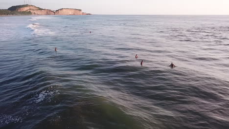 drone volando sobre la hermosa superficie del océano turquesa con turistas disfrutando de vacaciones en la playa de olón, ecuador