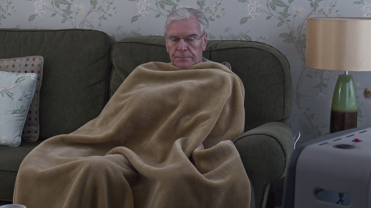 Worried senior keeping warm during the energy crisis - close-up shot