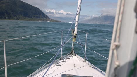 sailing boat bow with amazing alaskan coastline in background pov slow motion