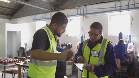 Colegas-Discutiendo-Mientras-Usan-Una-Tableta-En-La-Fábrica