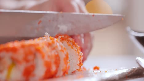 hacer sushi en la cocina de casa. manos de mujer enrollando sushi casero.