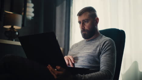 top view of anonymous mature male analyst in blue suit sitting at desk in corporate office, working on financial report on laptop, studying numbers and data on graphs and charts