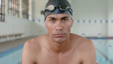 joven atleta masculino biracial listo para nadar en la piscina