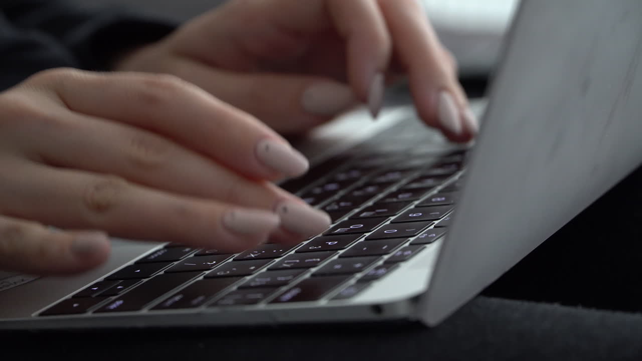Mani femminili premono i tasti sulla tastiera di un MacBook con layout russo