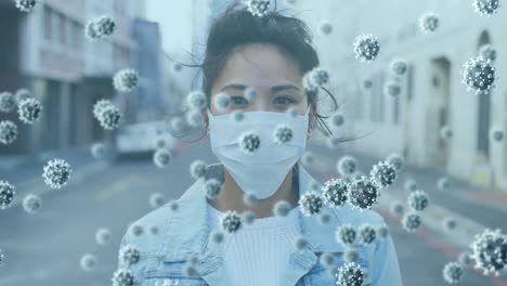 Covid-19-cells-floating-over-portrait-of-asian-woman-wearing-face-mask-on-the-street