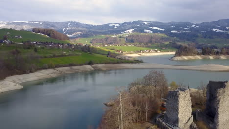 aerial forward ascending over ruins pont en ogoz castle on oiseaux isle, gruyere lake