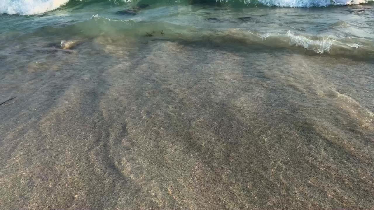 Pleasing and Peaceful View on Crystal Clear and Sandy Waves on the Beach with Blue Water
