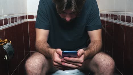 man using a phone in a bathroom