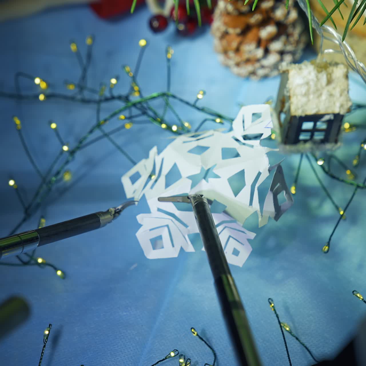 Gadget humanoid preparing snowflake from paper while preparing to the Christmas. Cropped view. Future technologies concept