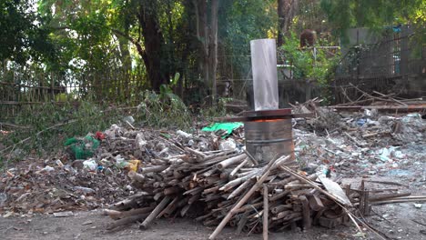 burning wood piles in forest with burn barrel wide shot forward chiang mai thailand 4k