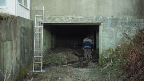 a man is removing the soil from an abandoned building - static shot