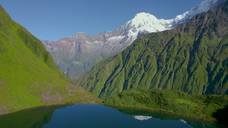 la montaña annapurna se refleja en el lago rodeada de vegetación paisaje nepalí disparado por un dron 4k