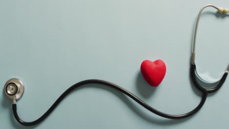 video of close up of stethoscope with heart on blue background