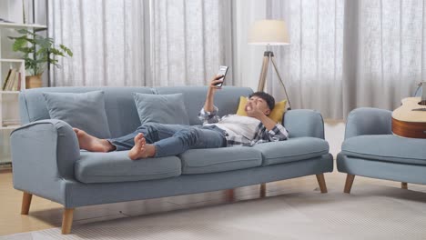 young person relaxing on a couch with smartphone