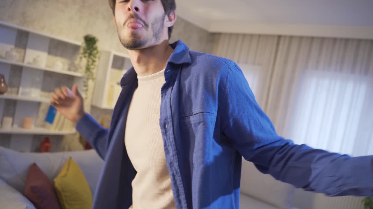 un joven gracioso bailando y divirtiéndose en casa.