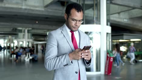 hombre de negocios usando un teléfono inteligente en la estación de tren