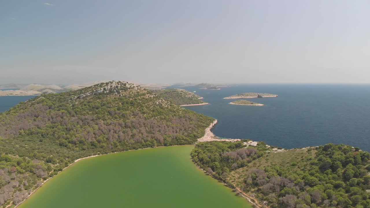 a professional looking aerial looking over a green salty lake, at the island of kornat, at the adriatic sea in south croatia