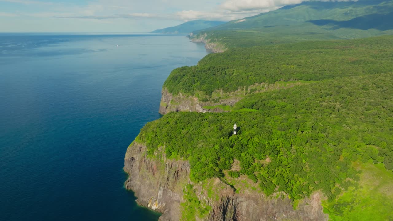 Aerial fly above Shiretoko National Park, cliff forest, sea landscape lighthouse tower, Hokkaido National Park
