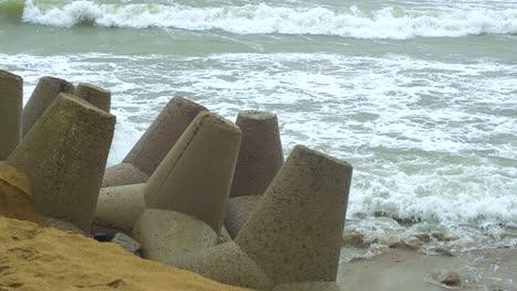 Waves-breaking-against-Karosta-Northern-Pier-at-Liepaja,-stormy-overcast-autumn-day,-slow-motion-medium-shot