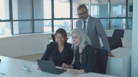 group of businesspeople using laptop for video talk