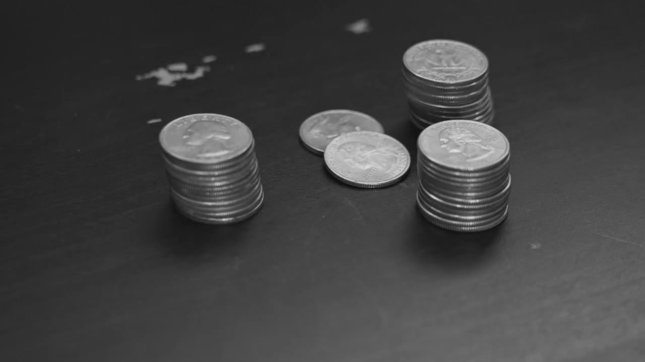 Black and white look of placing a neat stack of quarters.