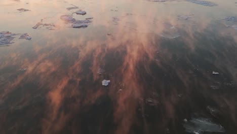 fotografía de seguimiento cinematográfico de nubes doradas moviéndose a través del mar abierto durante la puesta de sol, alaska