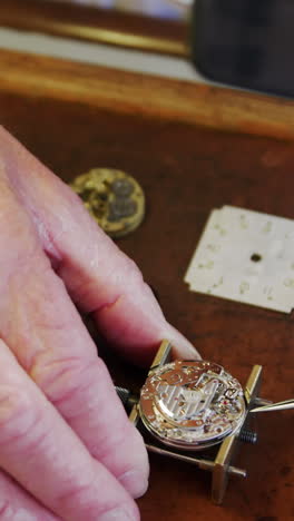 close-up of horologist hands repairing a watch