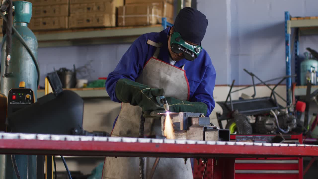 Video of african american female car mechanic using grinder, preparing car parts