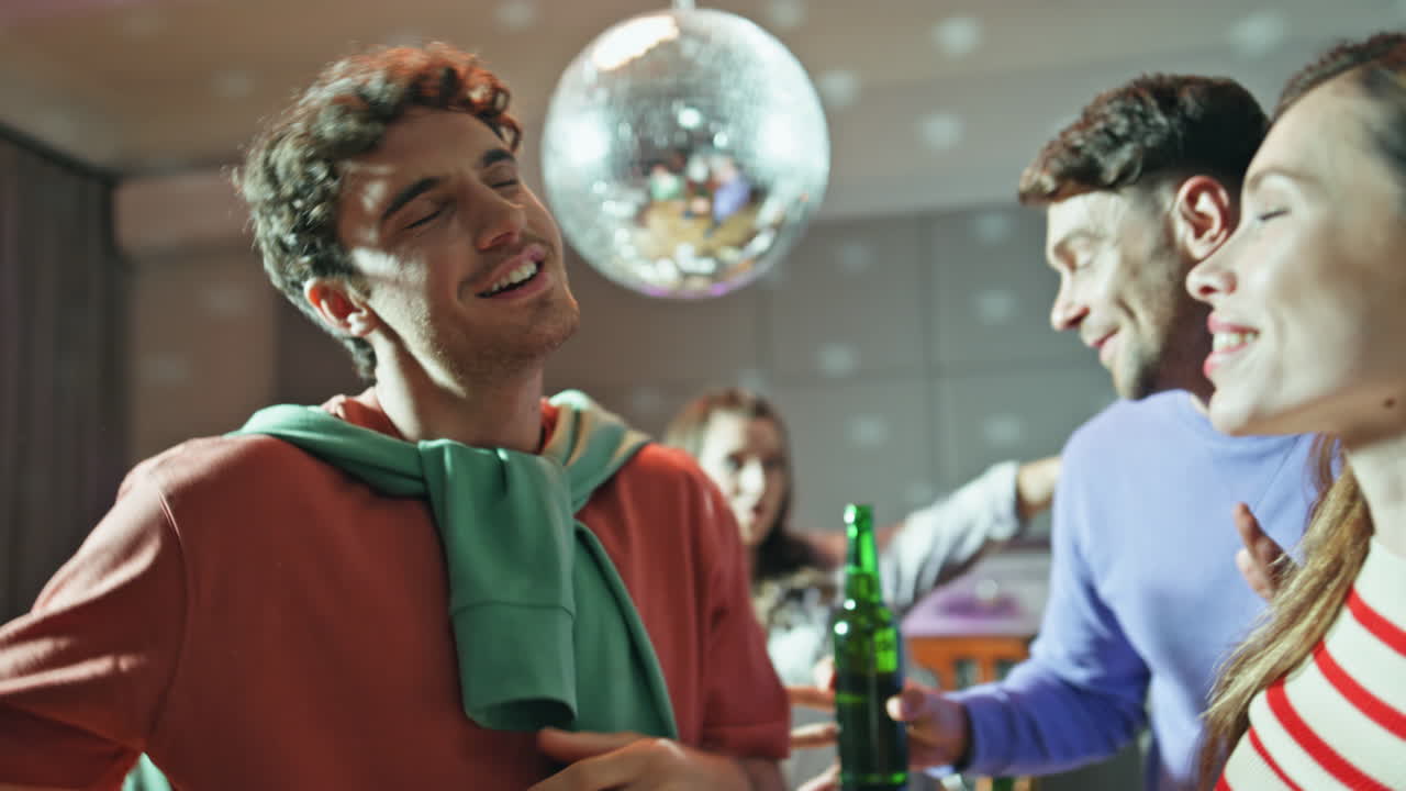 Smiling mates dancing together under disco ball close up. People moving bodies