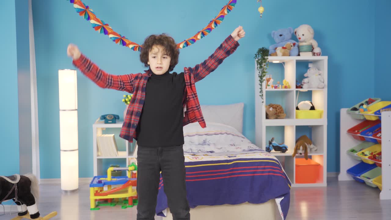 Cheerful and cute boy is dancing in his room.